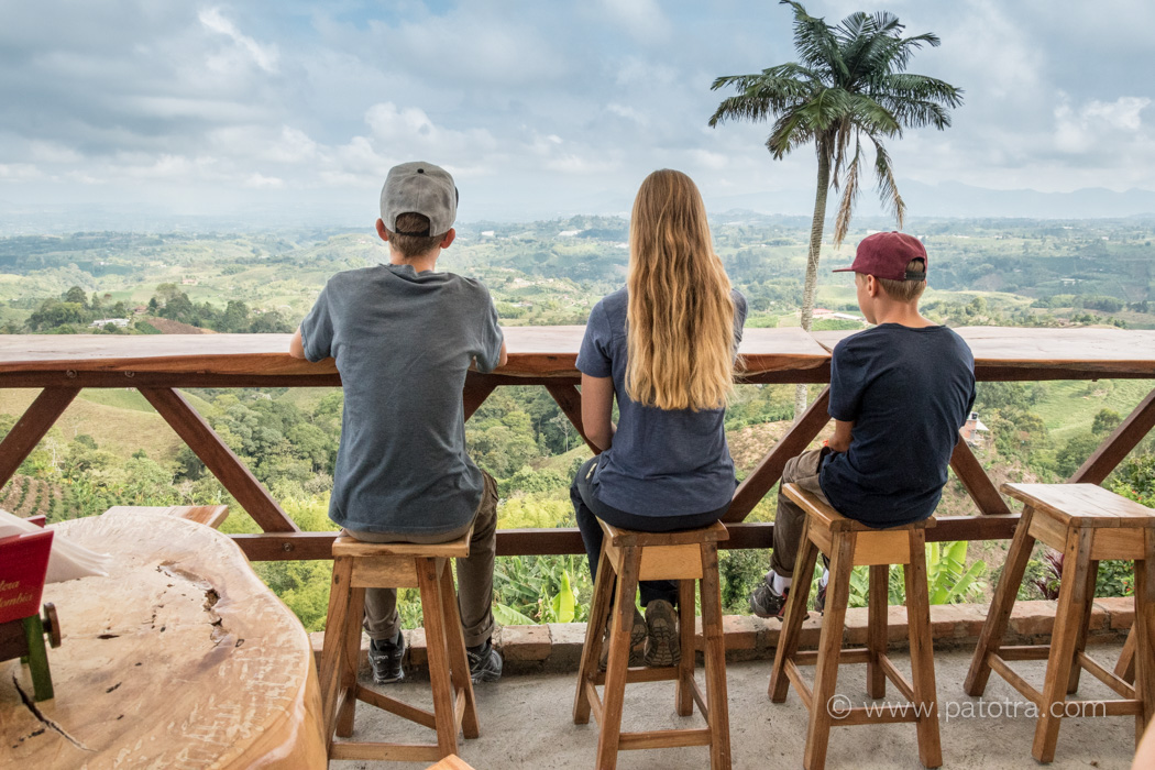 Drei Kinder sitzen in einer Bar uns schauen in die Kaffeezone Kolumbiens