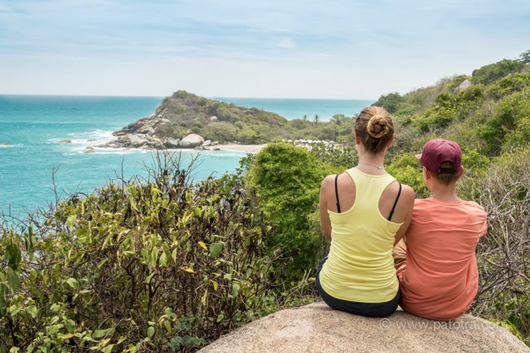 Kinder und Teenager im Tayrona Nationalpark auf einem Fels mit Blick auf das Meer der Karibik