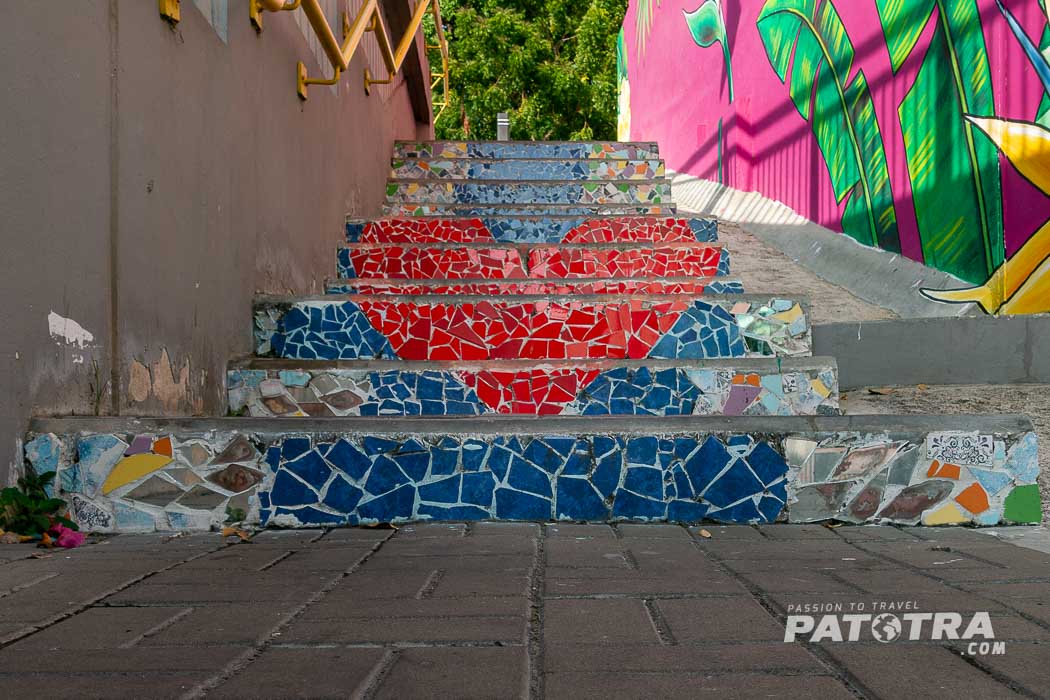 Treppenaufgang in Willemstad, Curacao. Die Stirnseiten der Stufen zeigen je ein Mosaik die zusammen ein rotes Herz vor blauem Hintergrund zeigen.
